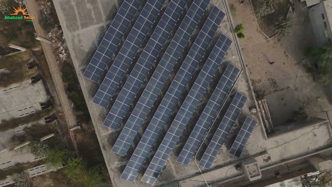 Large ground-mounted solar array spanning the yard of an industrial facility in Faisalabad
